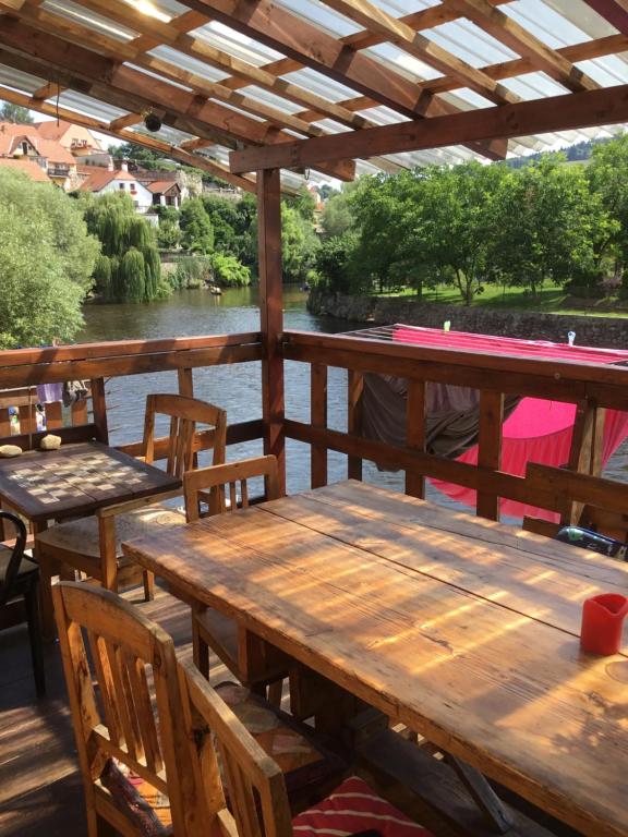 捷克克鲁姆洛夫Hostelskippy的河边甲板上的木桌和椅子