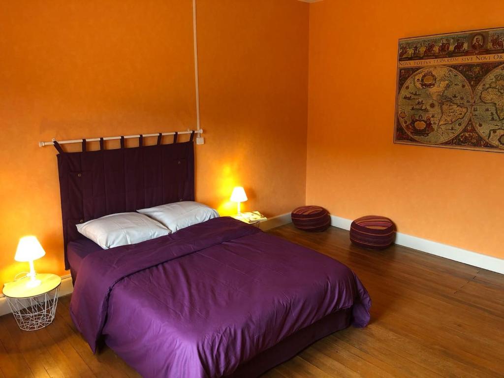 FaucompierreLE REVE DE CHARLES的一间卧室配有一张带紫色床单的床和两盏灯。