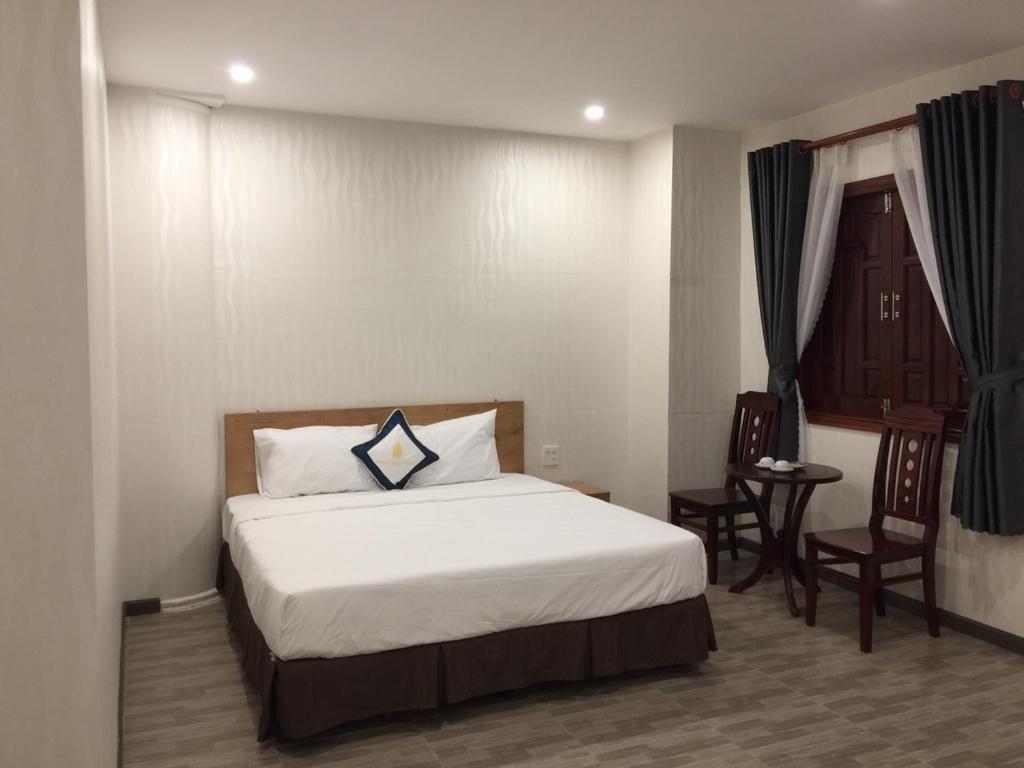 金瓯Thanh Truc Hotel Ca Mau的一间卧室配有一张带蓝色枕头的床
