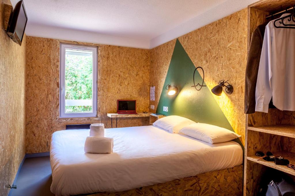 塞克兰Hôtel Moustache Lille - Seclin的卧室配有一张大白色床和窗户