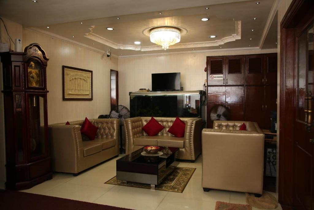 钦奈Grand View Residency Chennai的带沙发和红色枕头的客厅