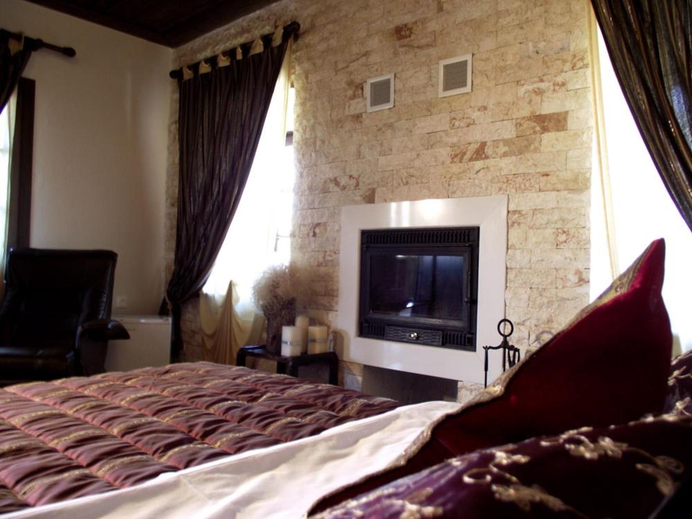 奥吉欧司吉玛洛斯Panorama Prespes的一间卧室设有一张大床和石墙