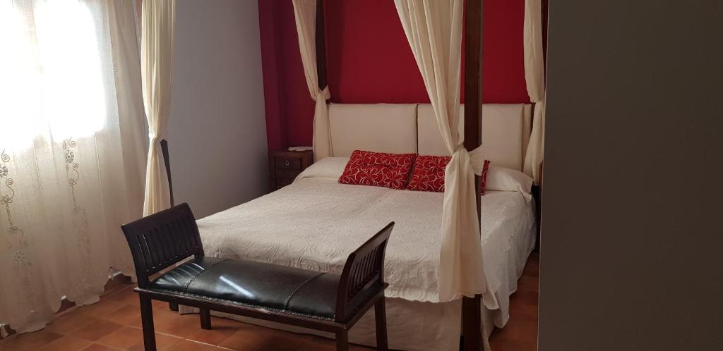 VillamielApartamentossierradegata La Noguera villamiel的一间卧室配有一张带椅子的床和一扇窗户