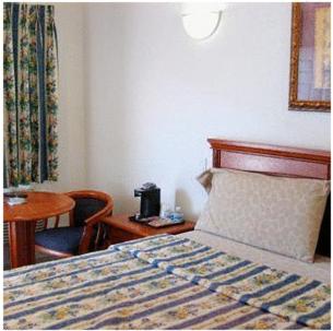 长滩长滩陶尔汽车旅馆的酒店客房,配有床、桌子和椅子