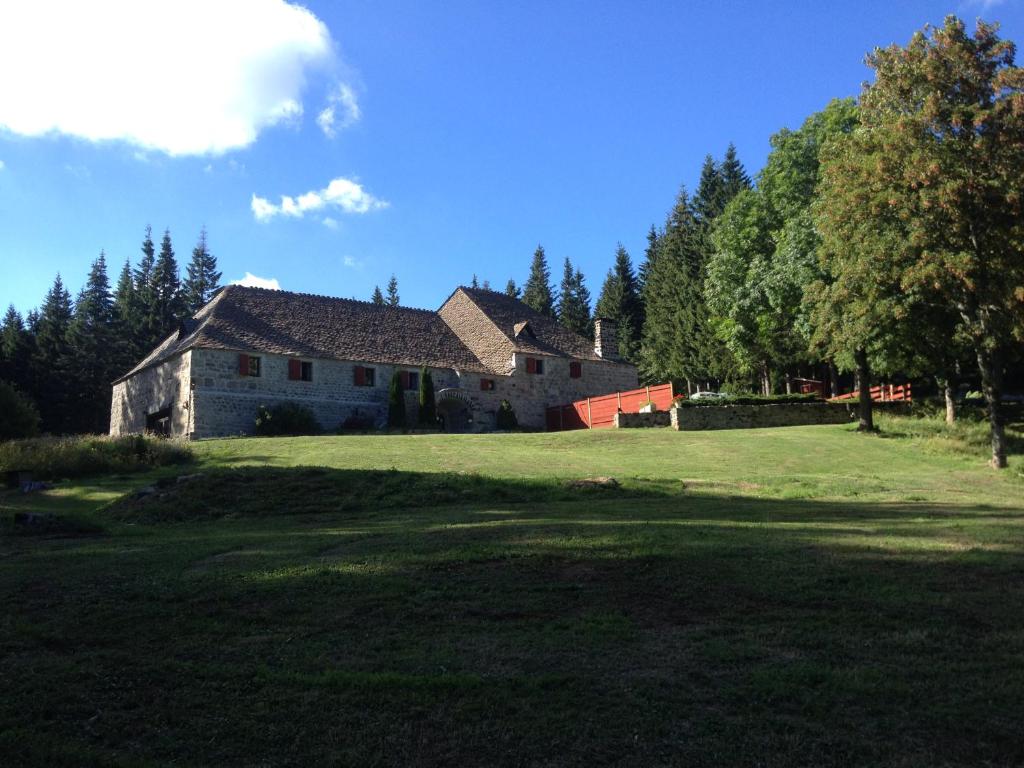 Saint-Cirgues-en-Montagne费朗迪拉克酒店的森林旁草地上的大型房子