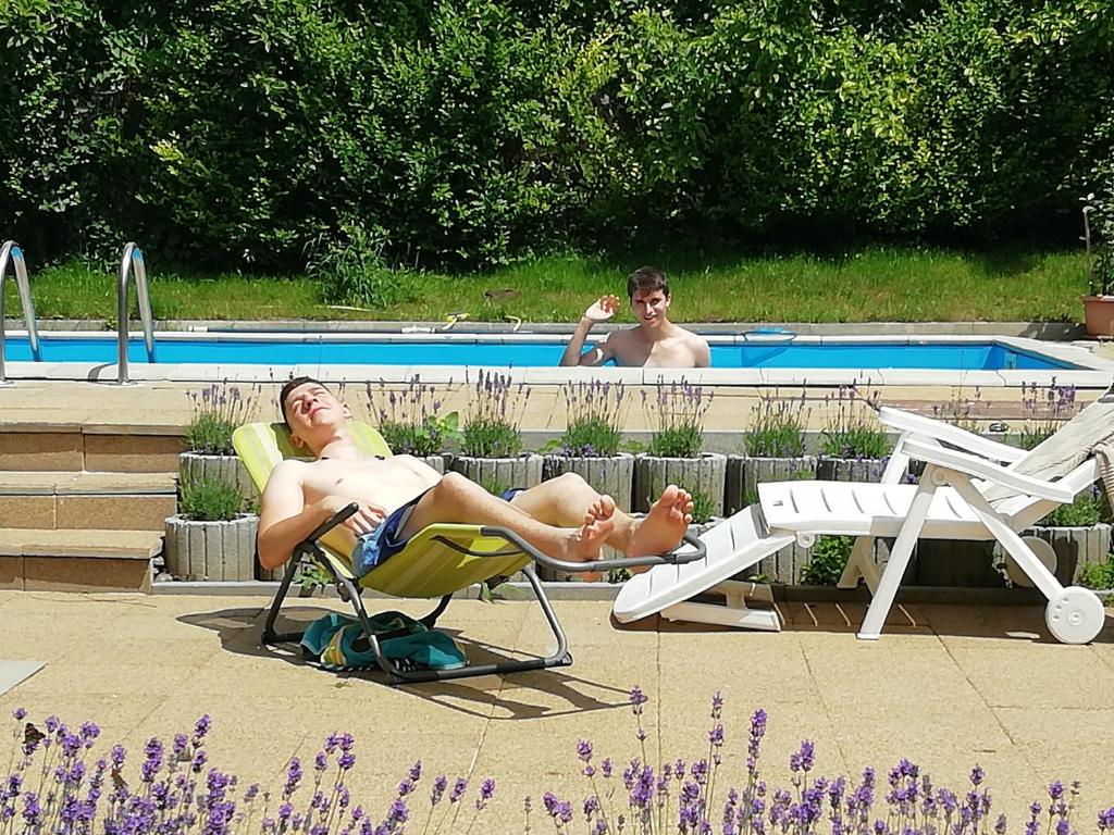 希欧福克阿内特公寓的几个人坐在游泳池旁的草坪椅上