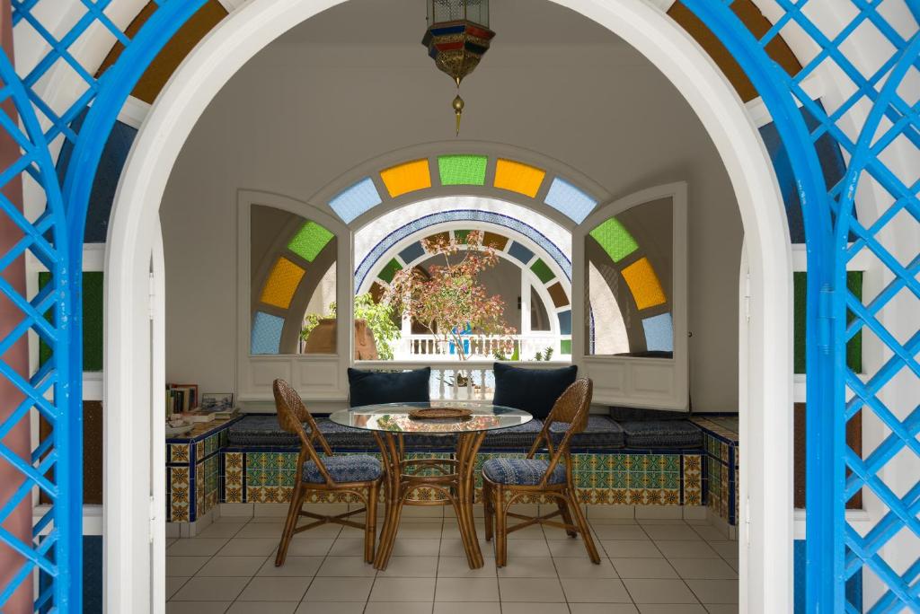 哈马马特腓尼基别墅酒店的一间带桌椅和窗户的用餐室