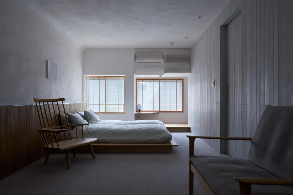 仓敷滔々 御崎 二階の宿 toutou Onzaki Nikai no Yado的一间卧室配有一张床、一把椅子和一张沙发