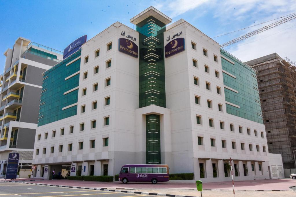 迪拜迪拜矽谷绿洲普瑞米尔酒店的停在前面的带货车的建筑