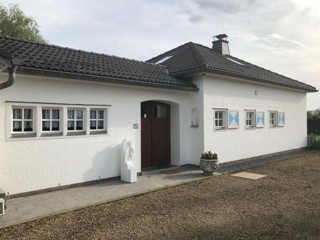 欧本Landhaus Sylvia的一间白色的房子,设有棕色的门