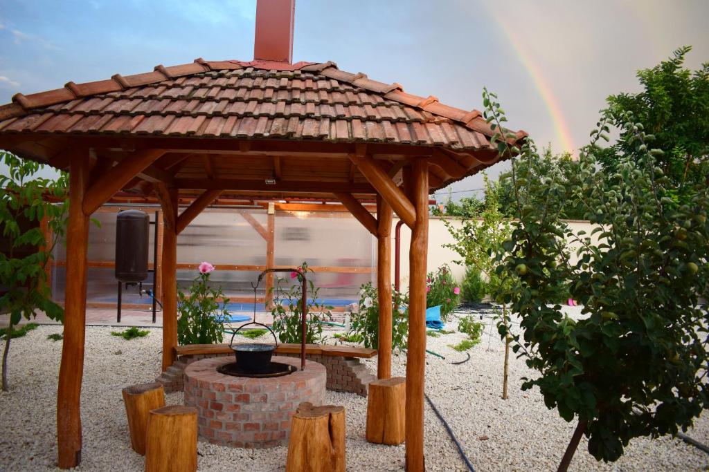 波罗斯洛Tündérfátyol vendégház的一个带彩虹的木制凉亭