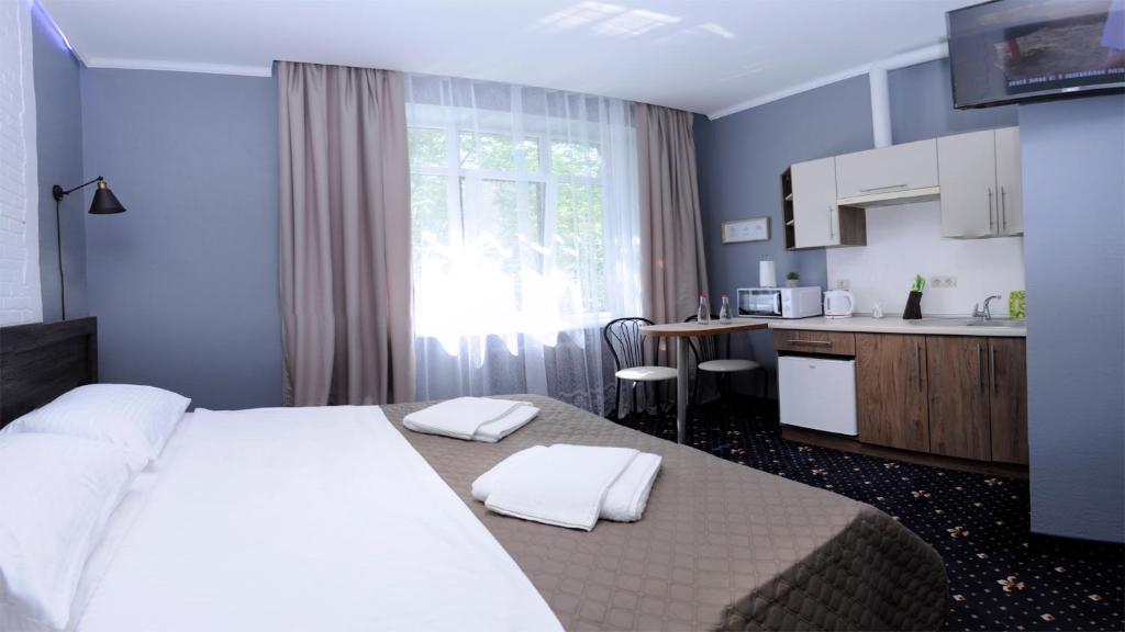 伊万诺-弗兰科夫斯克Luxury.ap的一间带白色大床的卧室和一间厨房