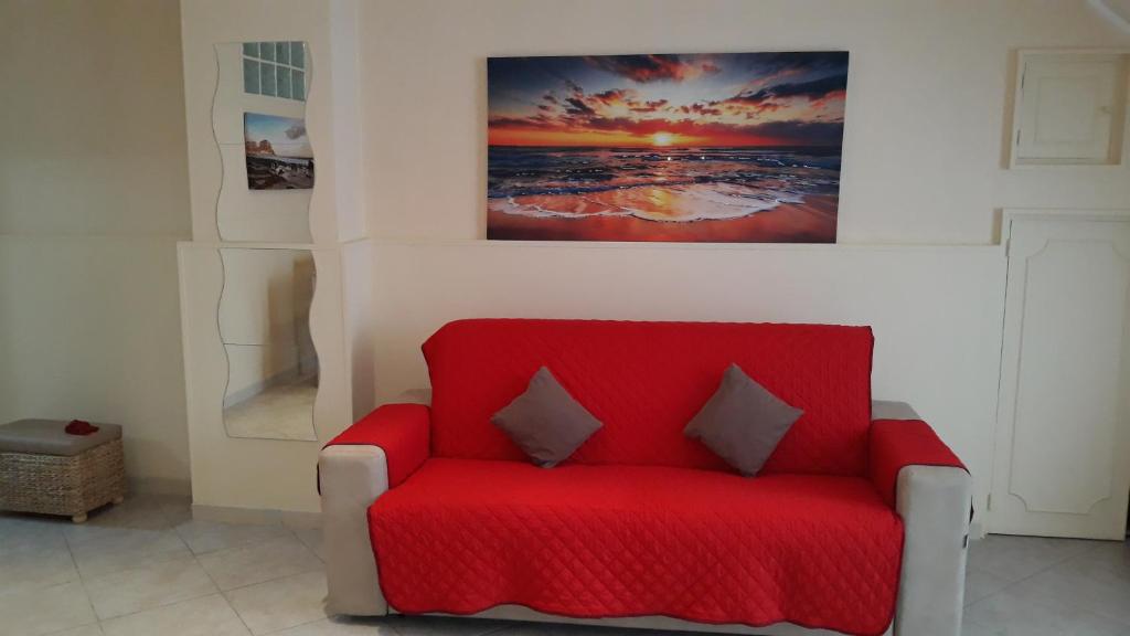 焦维纳佐Profumo di Mare (Sea's Perfume)的墙上一幅画的红色椅子