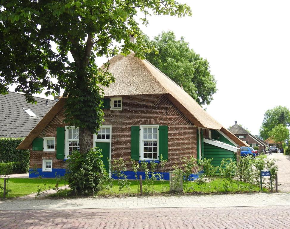 斯塔普霍斯特Vakantiehuis An Diek的一间小砖屋,设有绿色窗户