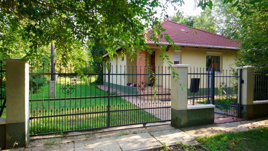 德布勒森Gyümölcsöskert Szálláshely的一座小房子前面的黑色围栏