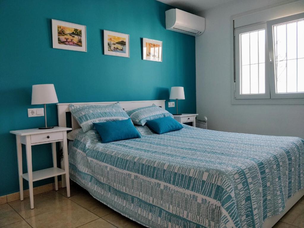 内尔哈Sunset view的一间卧室设有一张床和蓝色的墙壁