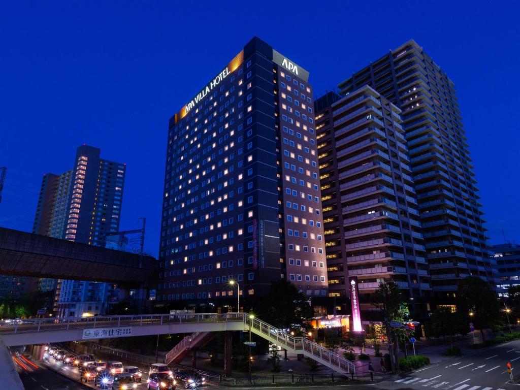 仙台APA Hotel Sendai-eki Itsutsubashi的一座高大的建筑,前面有交通
