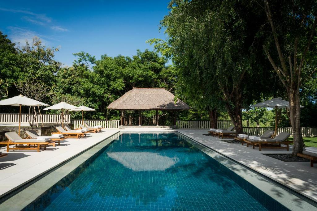 努沙杜瓦REVĪVŌ Wellness Resort Nusa Dua Bali的一个带躺椅和凉亭的游泳池