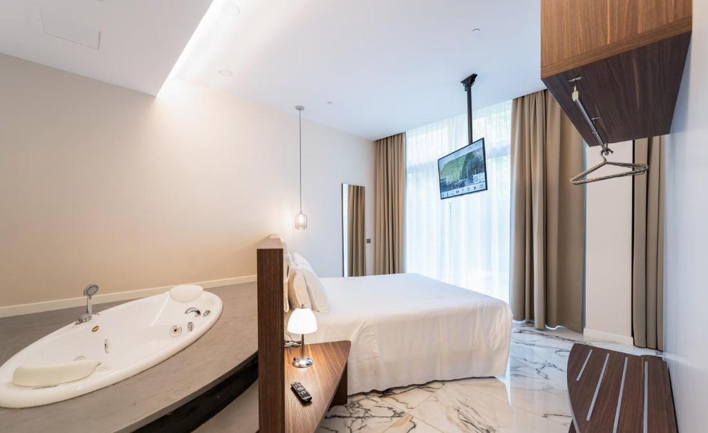 米兰米兰城堡酒店的带浴缸和床的酒店客房