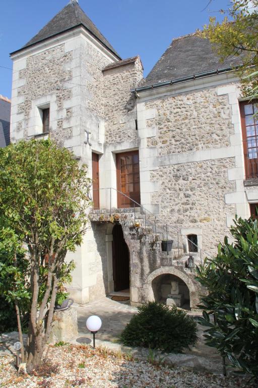 圣马丹勒博Gîte Au près du Lys的一座古老的石头建筑,侧面设有阳台