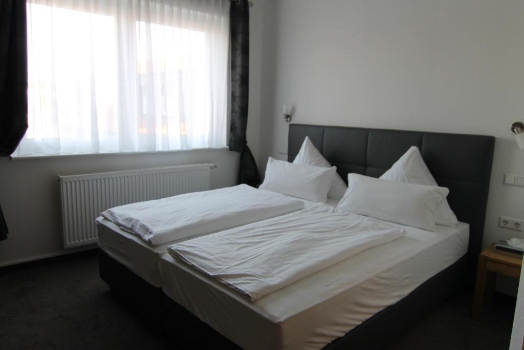 沃尔夫斯堡Hotel & Restaurant Blume的卧室内的一张带白色床单和枕头的床