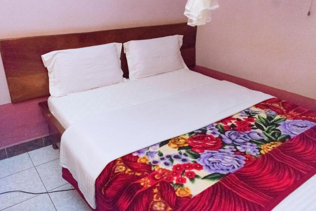 MbaleStarlight Hotel Mbale的一张位于酒店客房的床铺,上面有花毯