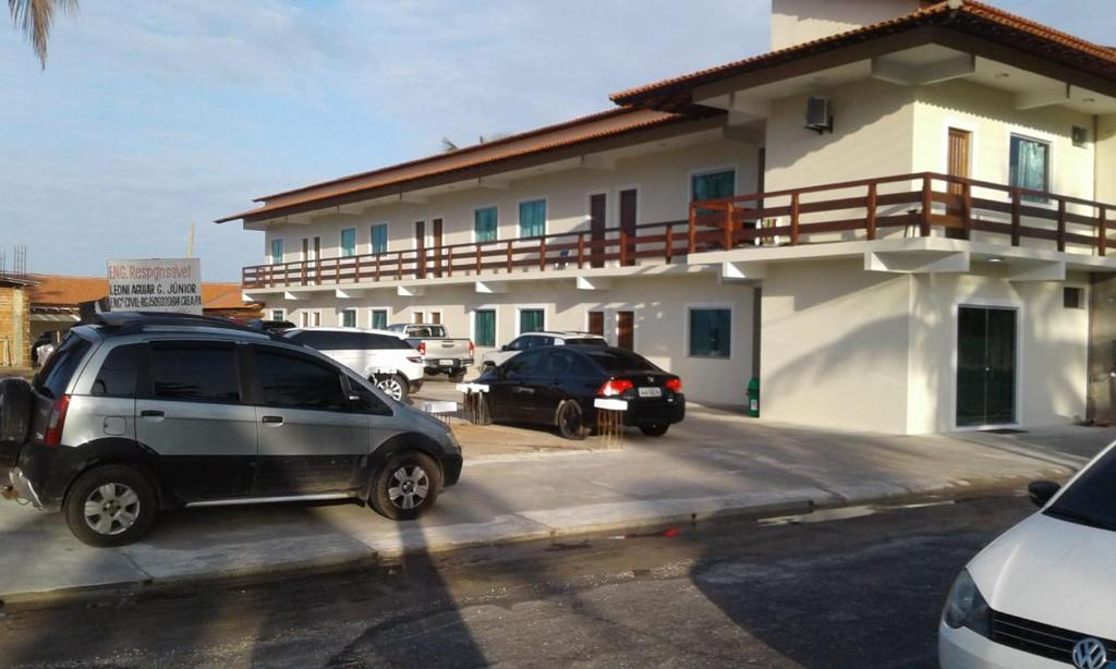 萨利诺波利斯Hotel Brio的两辆汽车停在房子前面的停车场