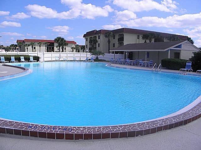 圣奥古斯丁St. Augustine Ocean & Racquet Resort的大楼前的大型蓝色游泳池
