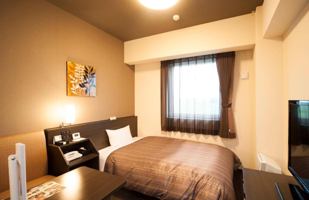 北九州鲁特因酒店 - 北九州市若松站东的酒店客房设有床和窗户。