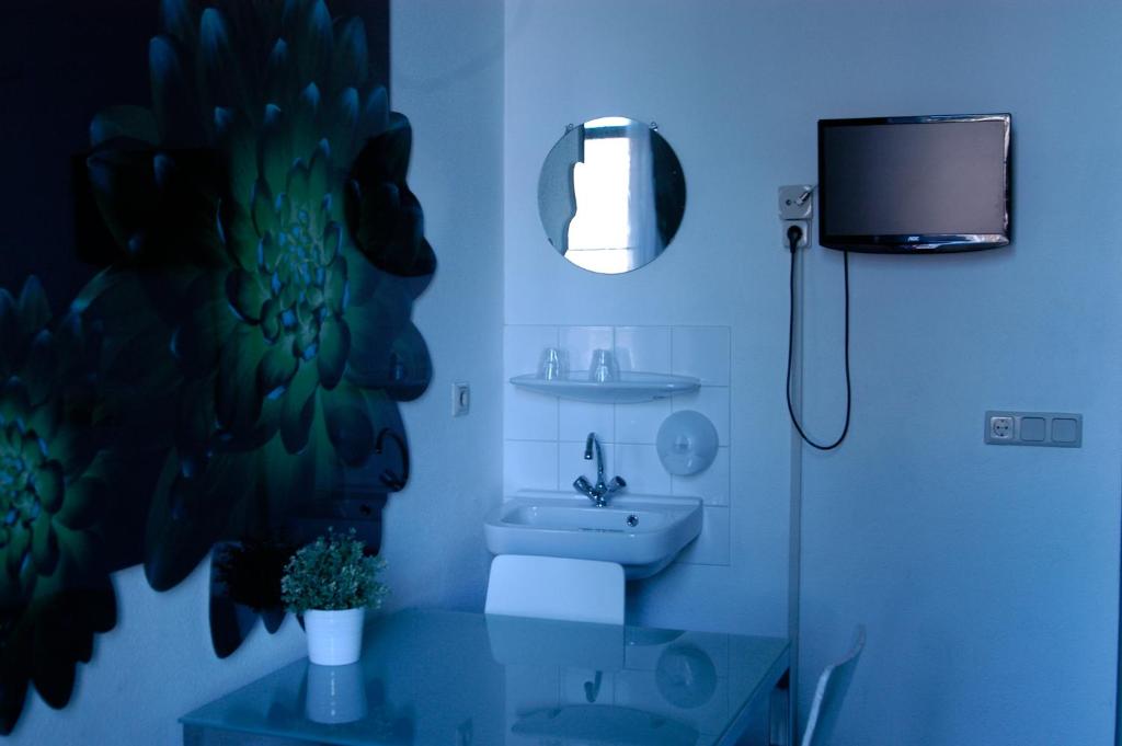 阿姆斯特丹伦勃朗广场酒店的一间带水槽和卫生间的浴室以及一台电视。