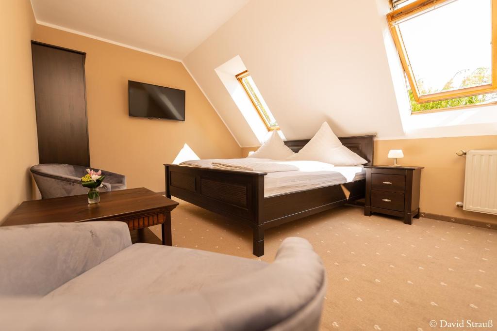 萨勒河畔瑙姆堡Hotel Wasserschlößchen的一间卧室配有一张床、一张沙发和一张桌子