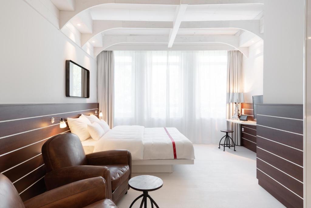 汉堡Ruby Lotti Hotel Hamburg的配有一张床和一把椅子的酒店客房