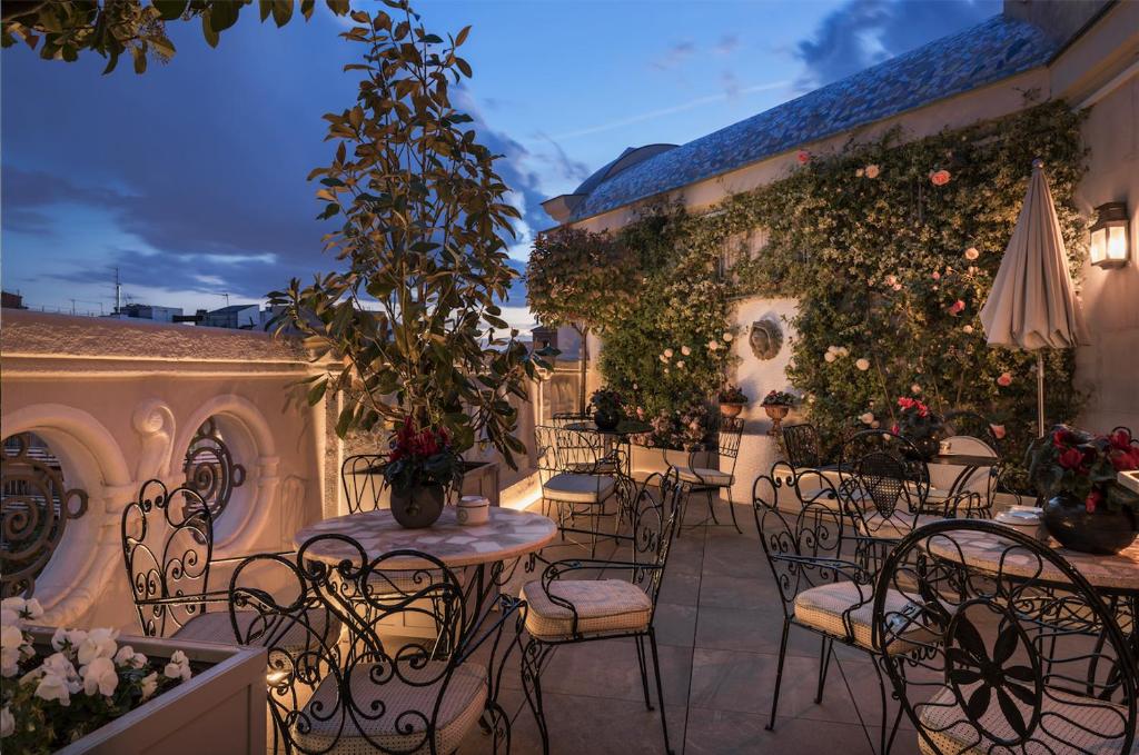 马德里Relais & Châteaux Heritage Hotel的户外庭院设有桌椅和植物