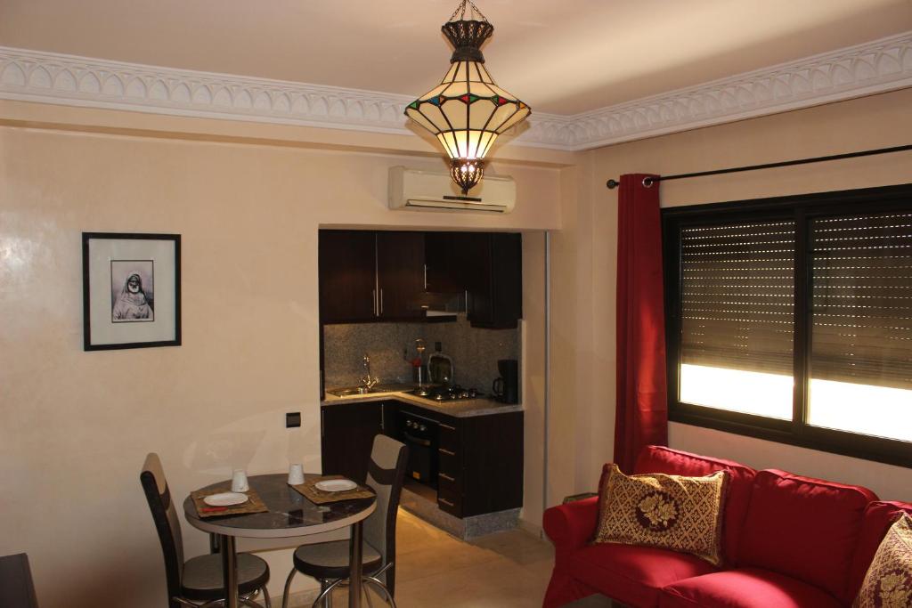 马拉喀什Studio Salmiya Dune的客厅配有桌子和红色沙发