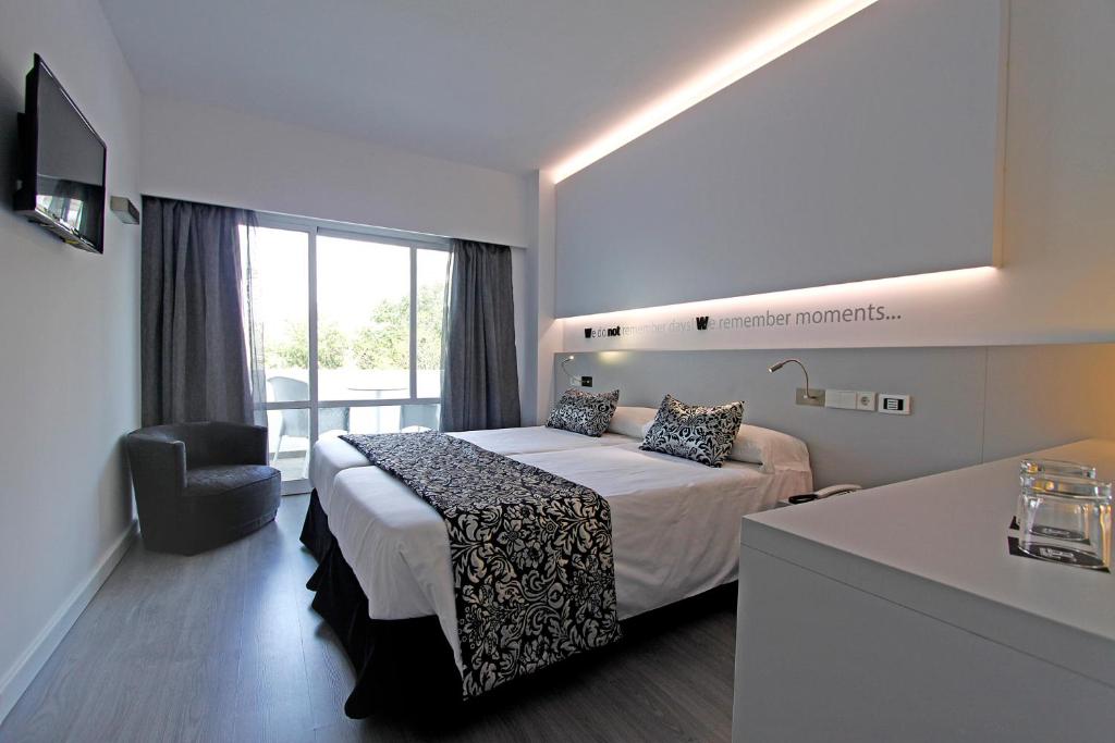 帕尔马海滩BG Pamplona的配有一张床和一把椅子的酒店客房