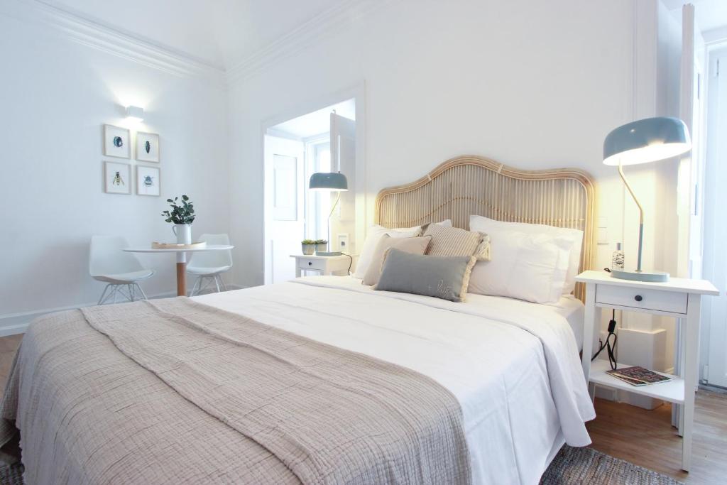 埃武拉Lavradores Boutique Guesthouse的白色卧室配有一张带白色床单和枕头的大床