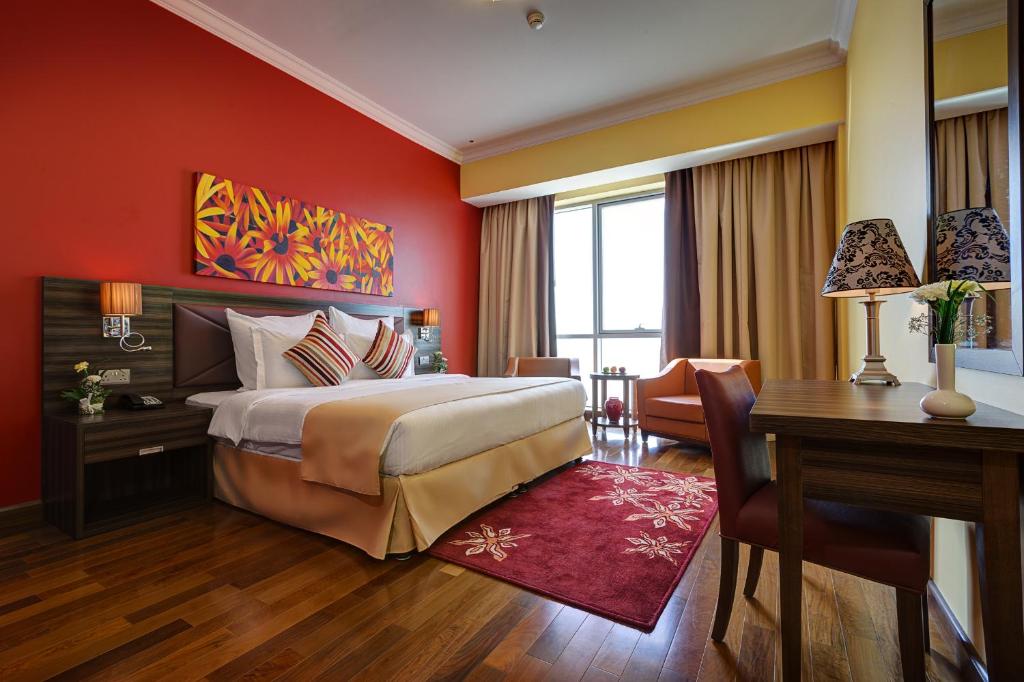 迪拜迪拜兰德阿拜德斯公寓酒店的酒店客房设有一张大床、一张书桌和一张书桌。