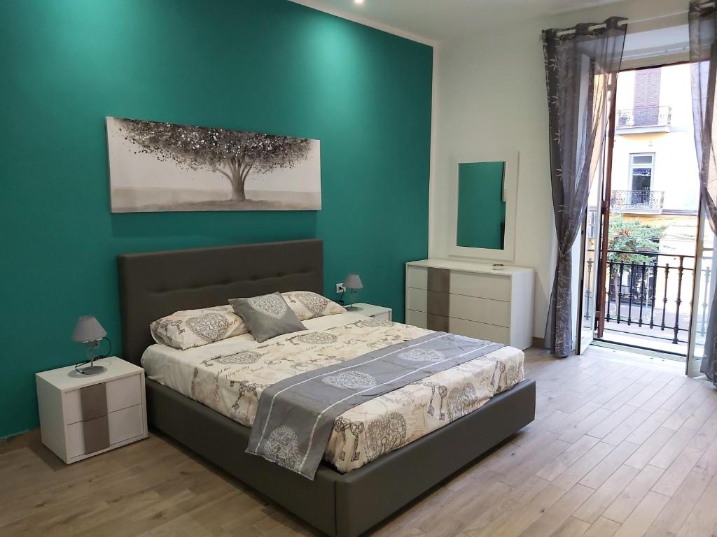 那不勒斯Dormire a Napoli Centro Holiday House Casa Vacanza的一间卧室设有一张床和绿色的墙壁