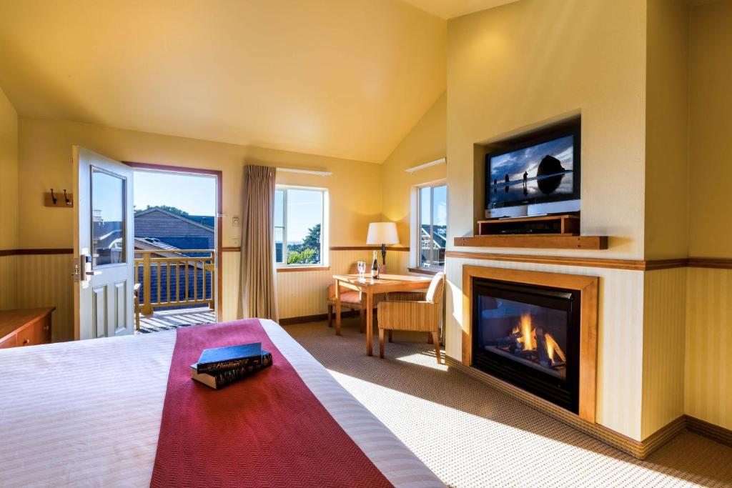 卡农海滩坎农比奇酒店的酒店客房设有壁炉和电视。