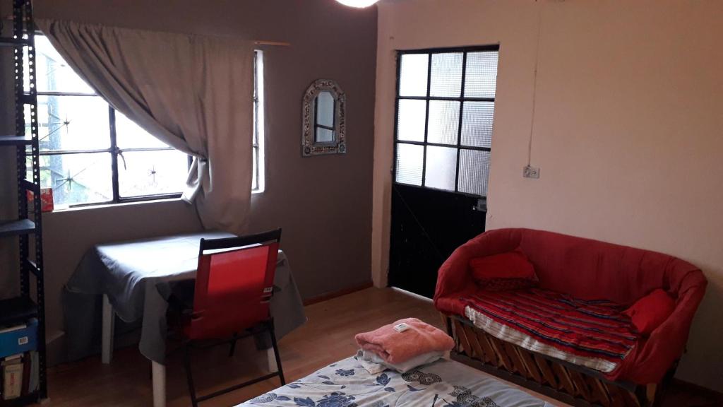 莫雷利亚El laberinto hospedaje en casa的客厅配有红色的沙发和桌子