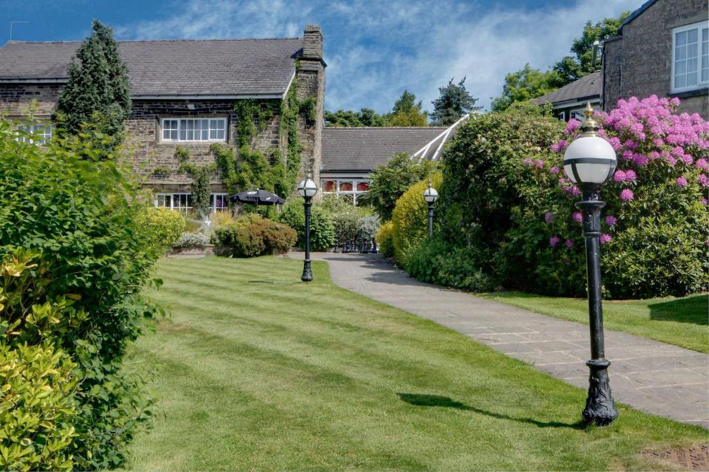 斯凯尔默斯代尔B/W Plus Lancashire Manor Hotel的房屋前带两个灯柱的花园
