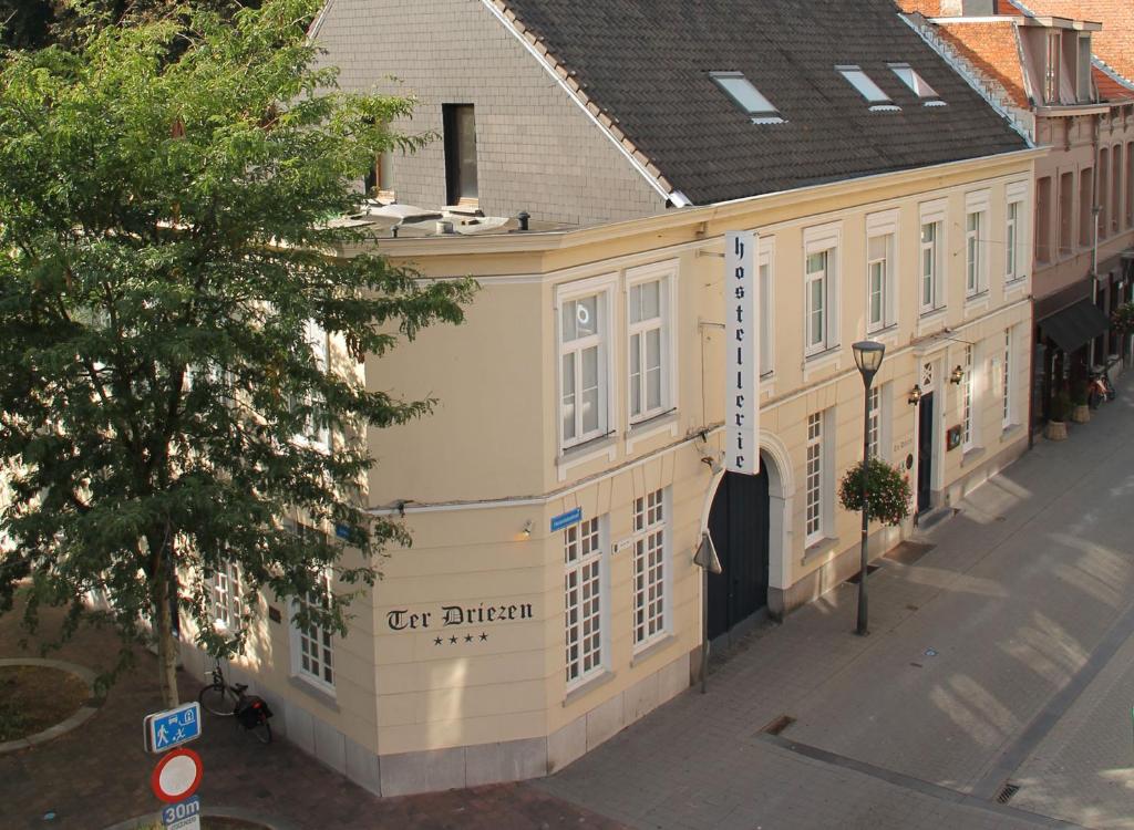 蒂伦豪特泰尔德里岑酒店的街道上白色的建筑,上面有标志