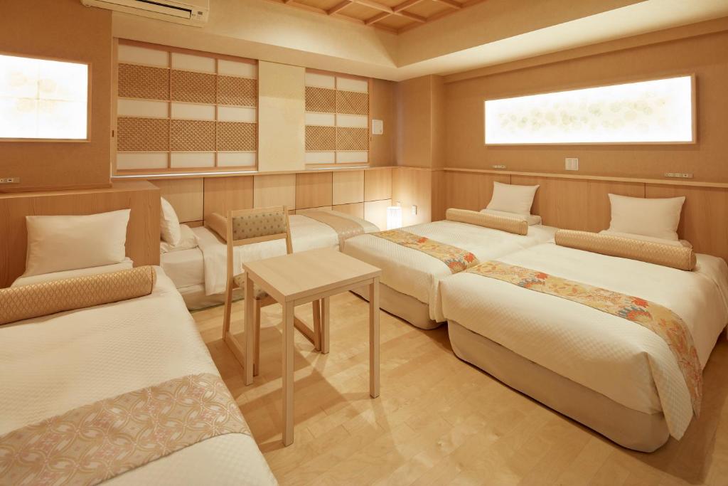 东京MYSTAYS 浅草桥酒店的带三张床和桌椅的房间