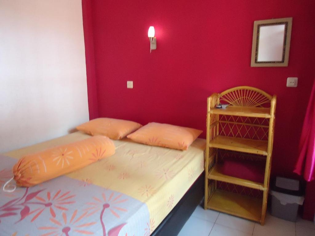 庞岸达兰Kancil homestay的一间卧室设有两张床和红色的墙壁