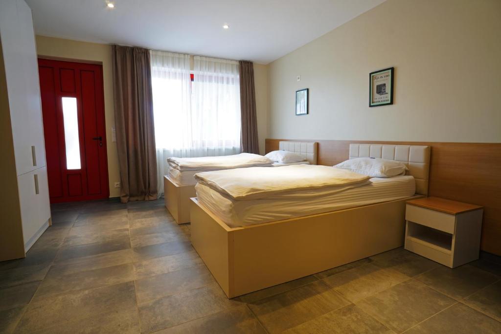维也纳新城Nava Motel & Storage的红色门的房间里设有两张床