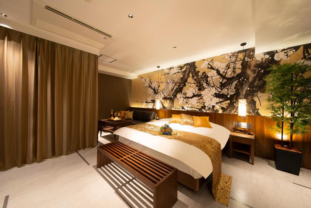 岐阜ホテル Tiger & Dragon 男塾ホテルグループ的卧室配有一张床,墙上挂有绘画作品