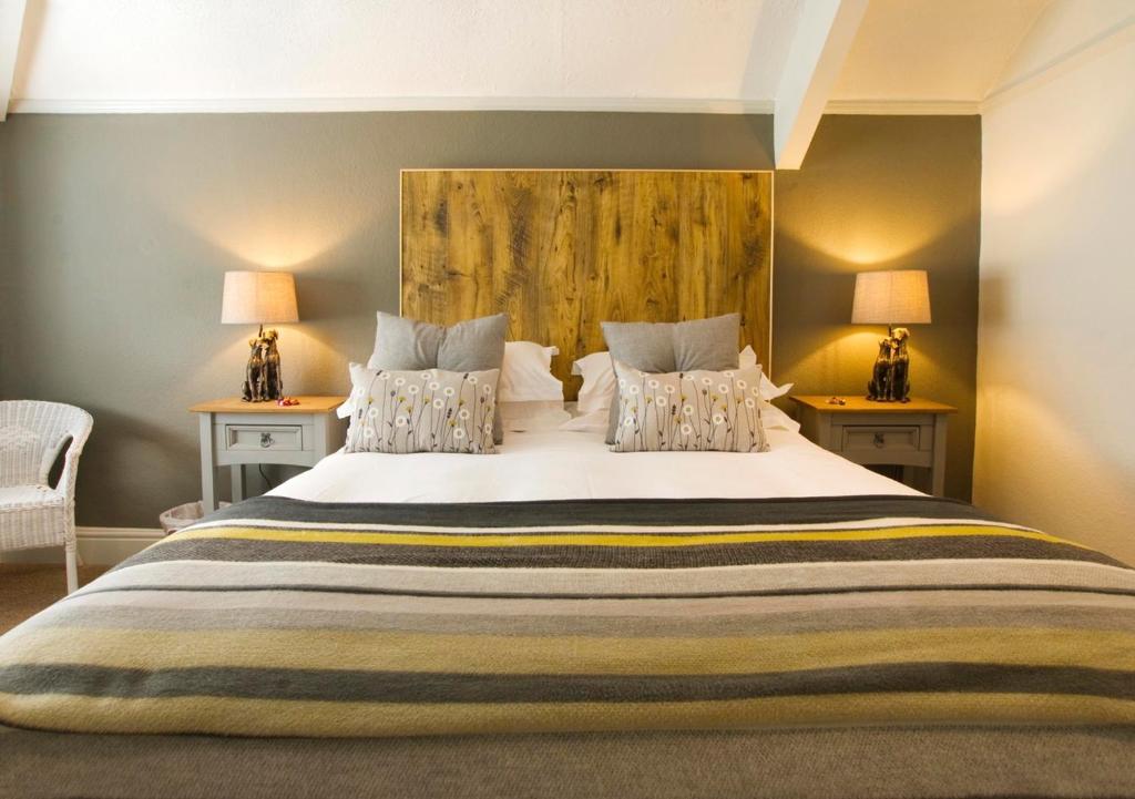 托特尼斯Hunters Lodge Inn的一间卧室配有一张带两盏灯的大型白色床。