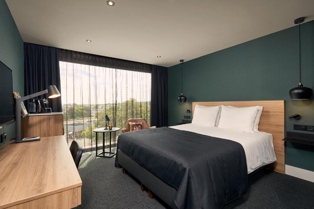 安特卫普安特卫普范德瓦尔克酒店的一间卧室设有一张床和一个大窗户