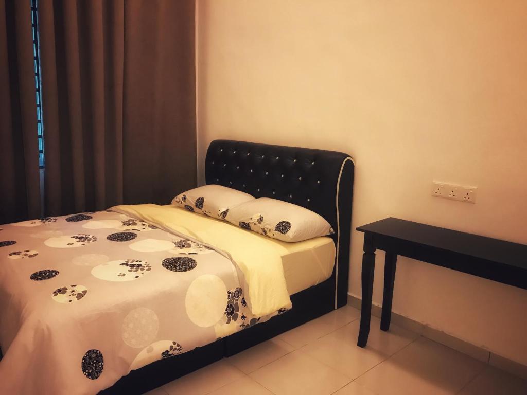 樟仑Arsyad Homestay Changlun的一张带黑色床头板和桌子的床