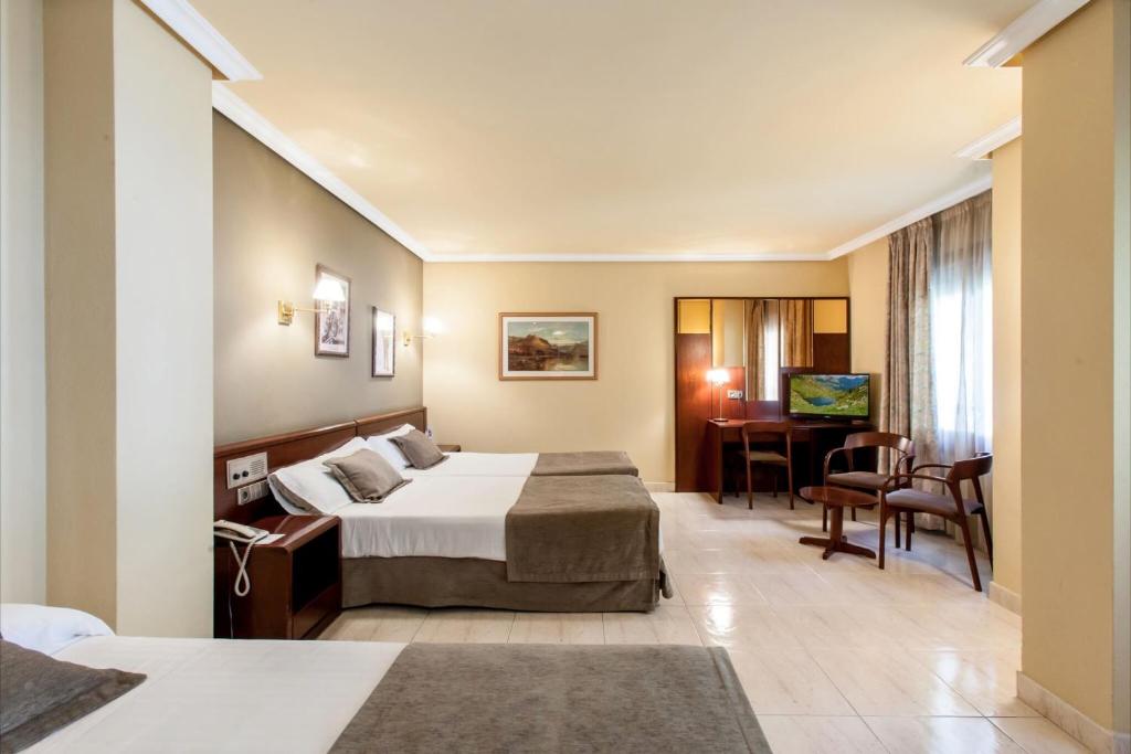 圣胡利娅-德洛里亚Yomo Imperial的配有一张床和一张书桌的酒店客房